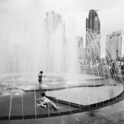 children playing in fountain in Shanghai, China.